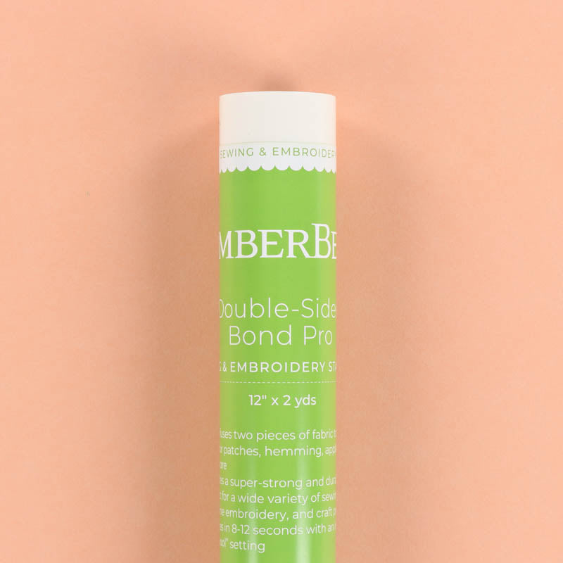 Green tube of Kimberbell Double-Sided Bond Pro on a peach background