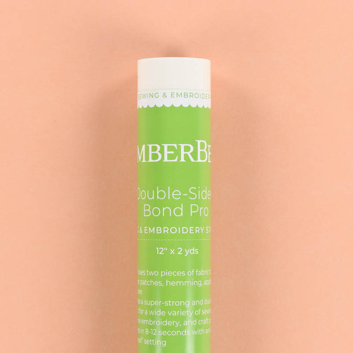 Green tube of Kimberbell Double-Sided Bond Pro on a peach background
