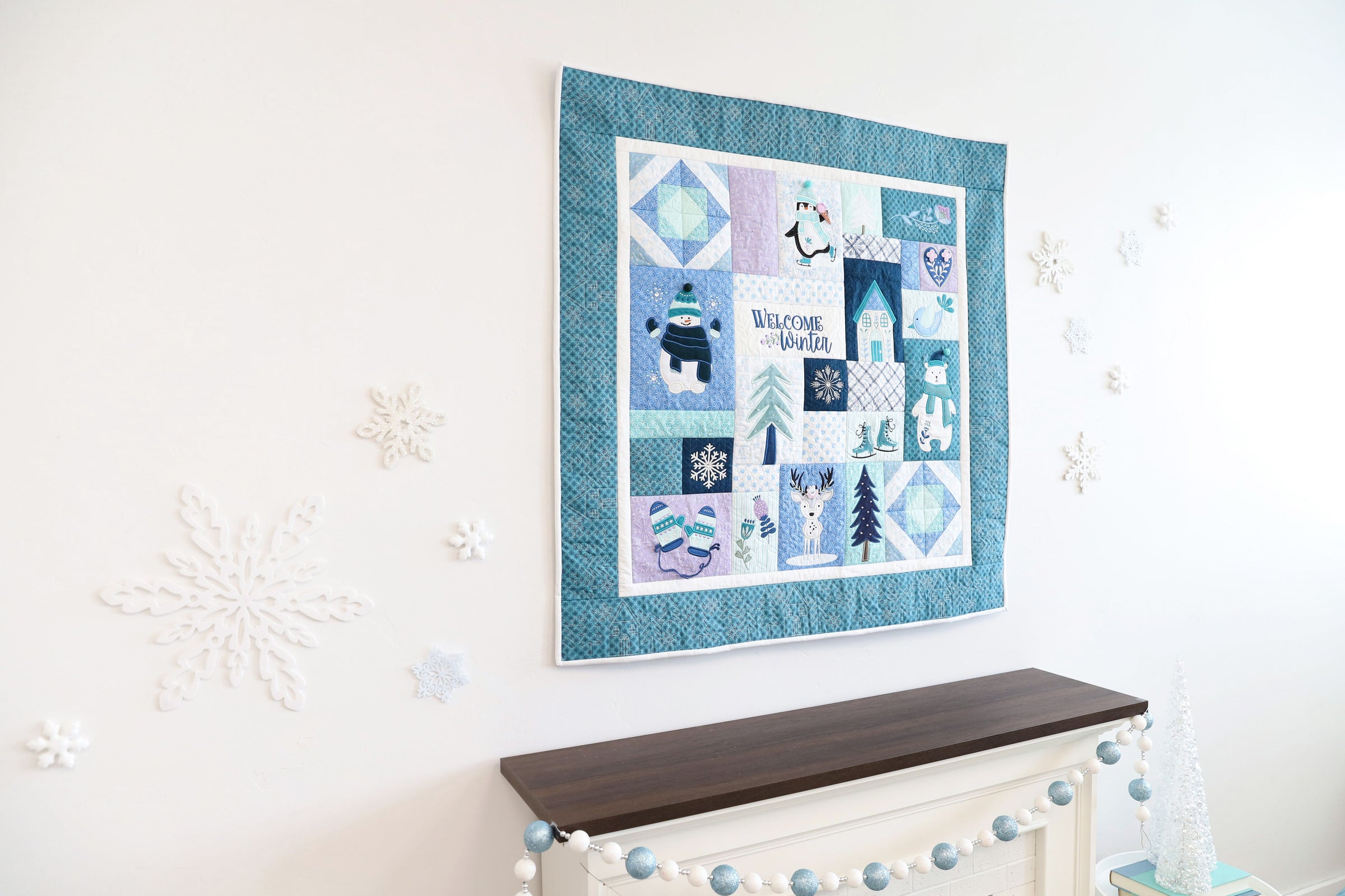 Enchanted Winter, winter-themed patterns hanging on a wall above a console table.