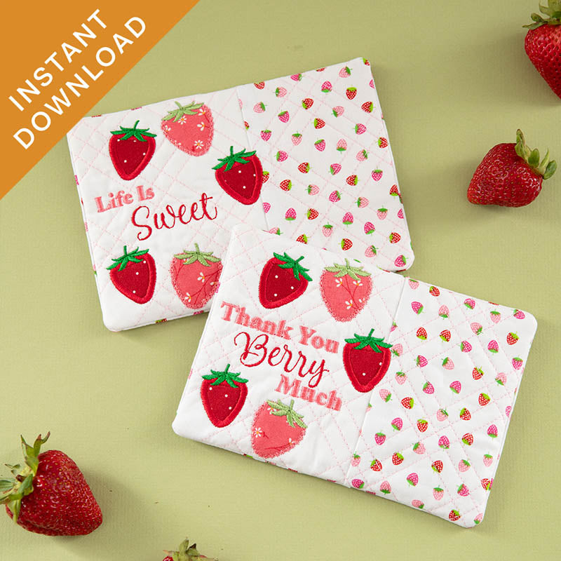 Two quilted mug rugs with strawberry pattern, alongside "Life Is Sweet" and "Thank You Berry Much" embroidered text. 