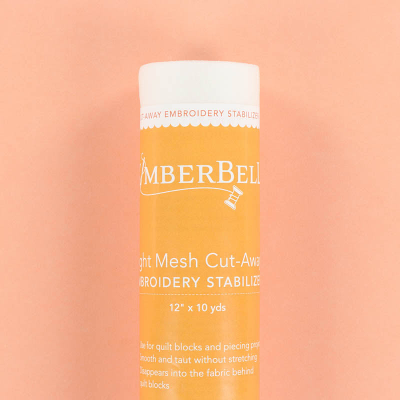 A Light-Mesh Cut-Away Kmberbell embroidery stabilizer roll on a peach background