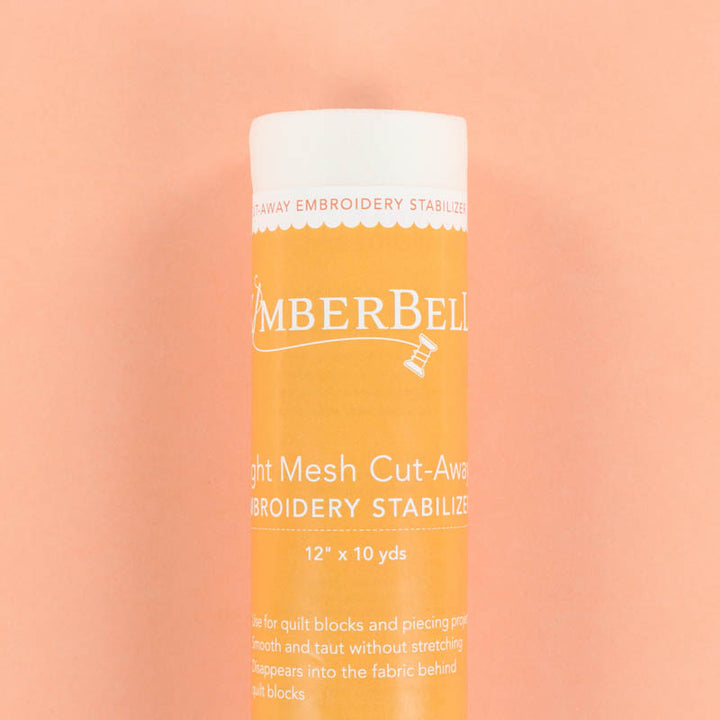 A Light-Mesh Cut-Away Kmberbell embroidery stabilizer roll on a peach background