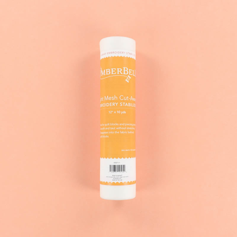 Roll of Light-Mesh Cut-Away Kimberbell embroidery stabilizer on a peach background