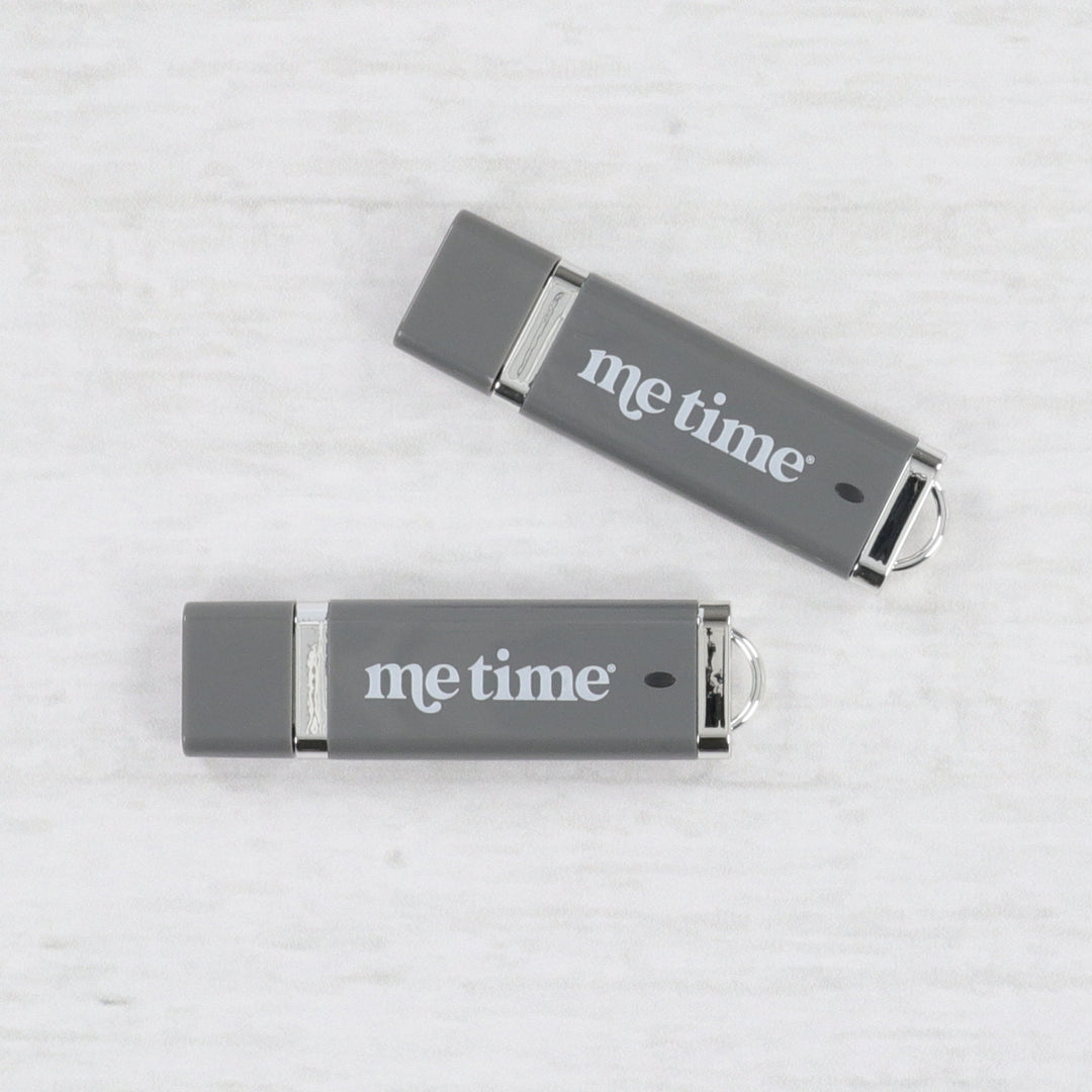 Two gray USB drives with 'Me Time' text on a light gray background