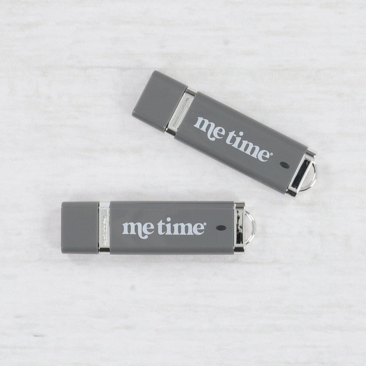 Two gray USB drives with 'Me Time' text on a light gray background