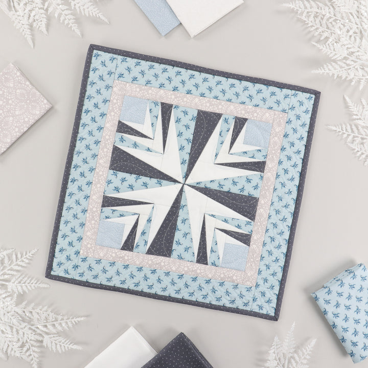 Quilt displaying a geometric pattern on a light gray background.