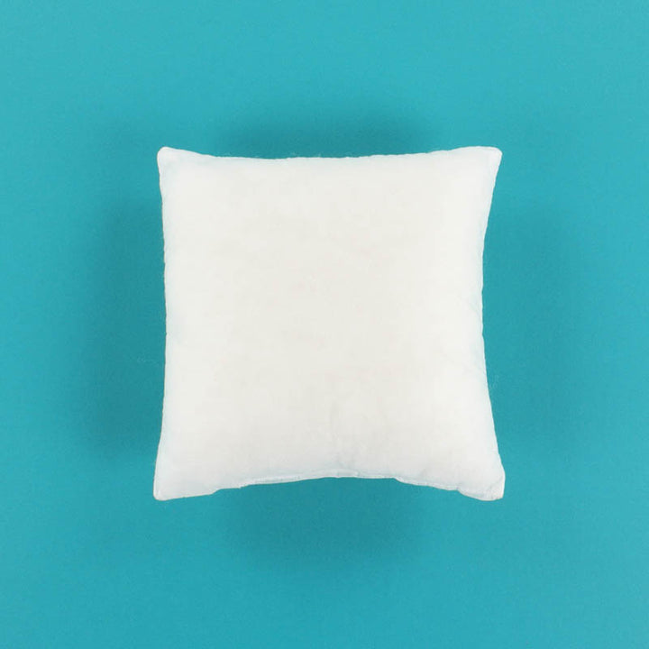 White pillow insert on a teal background