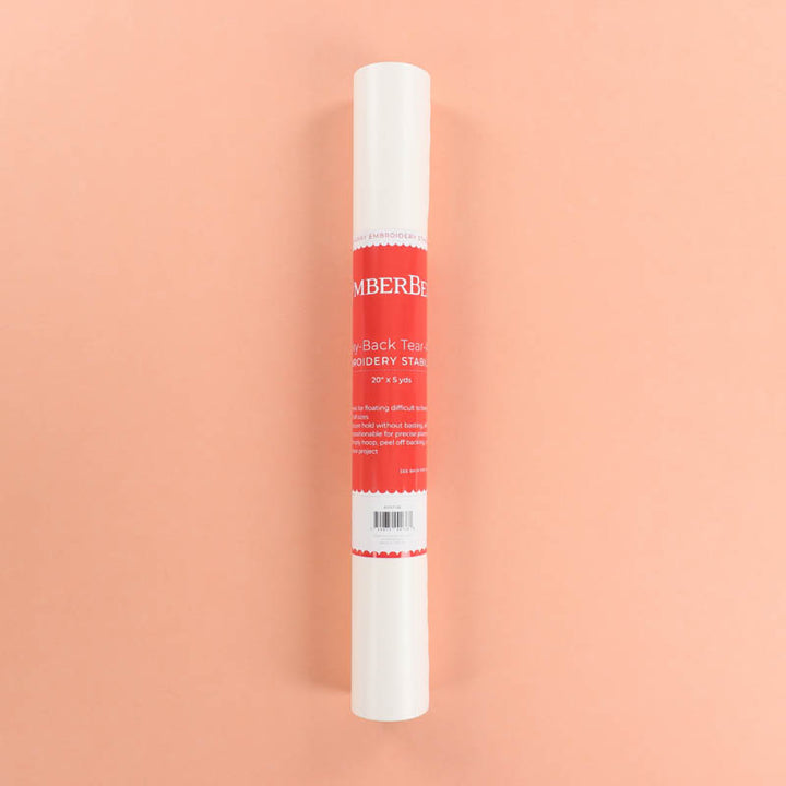 Roll of embroidery stabilizer with a red label on a peach background