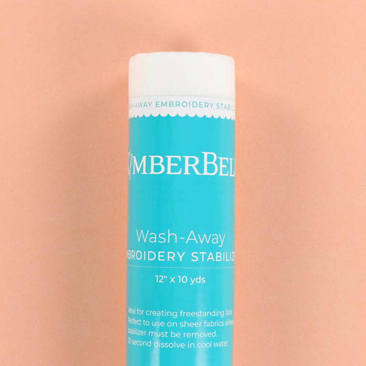 Blue roll of Kimberbell Wash-Away Embroidery Stabilizer on a peach background