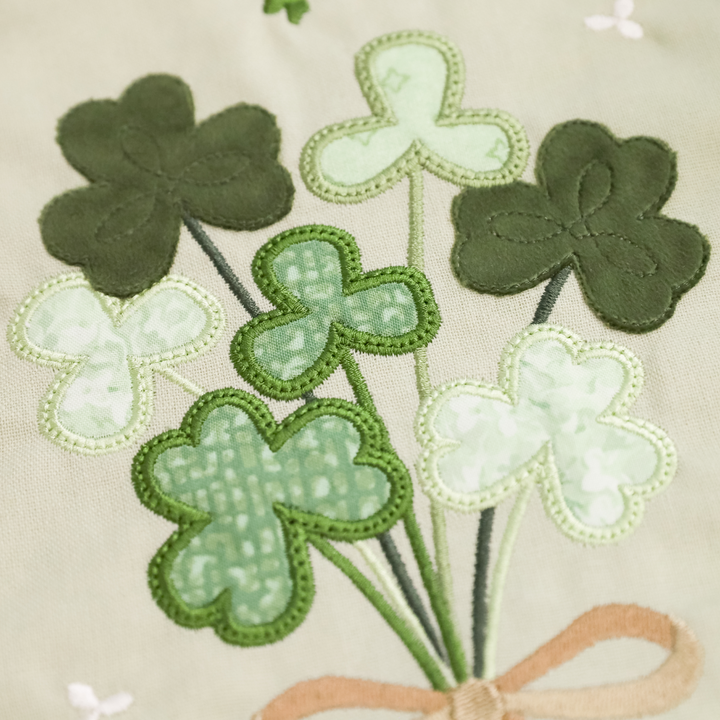 Embroidered shamrocks with a bow on a beige background
