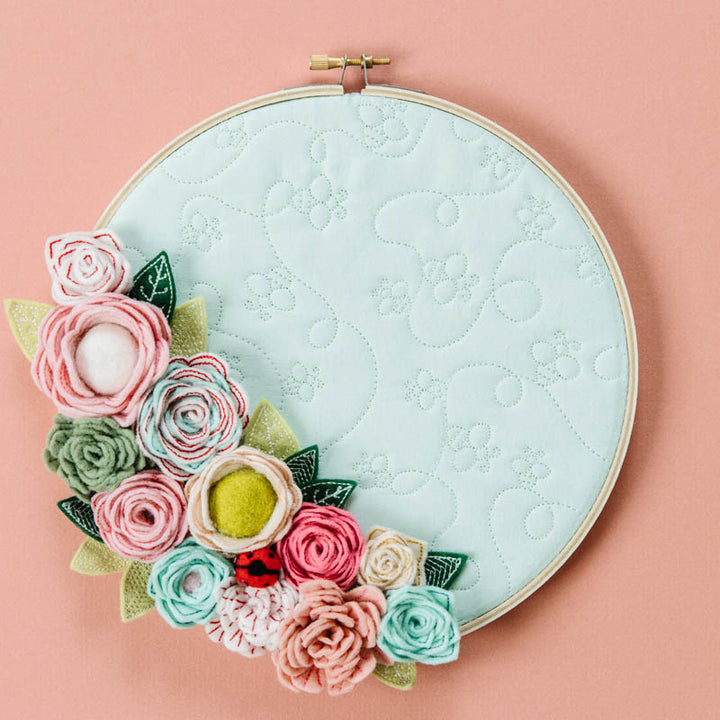 Embroidery hoop with floral design on a pink background